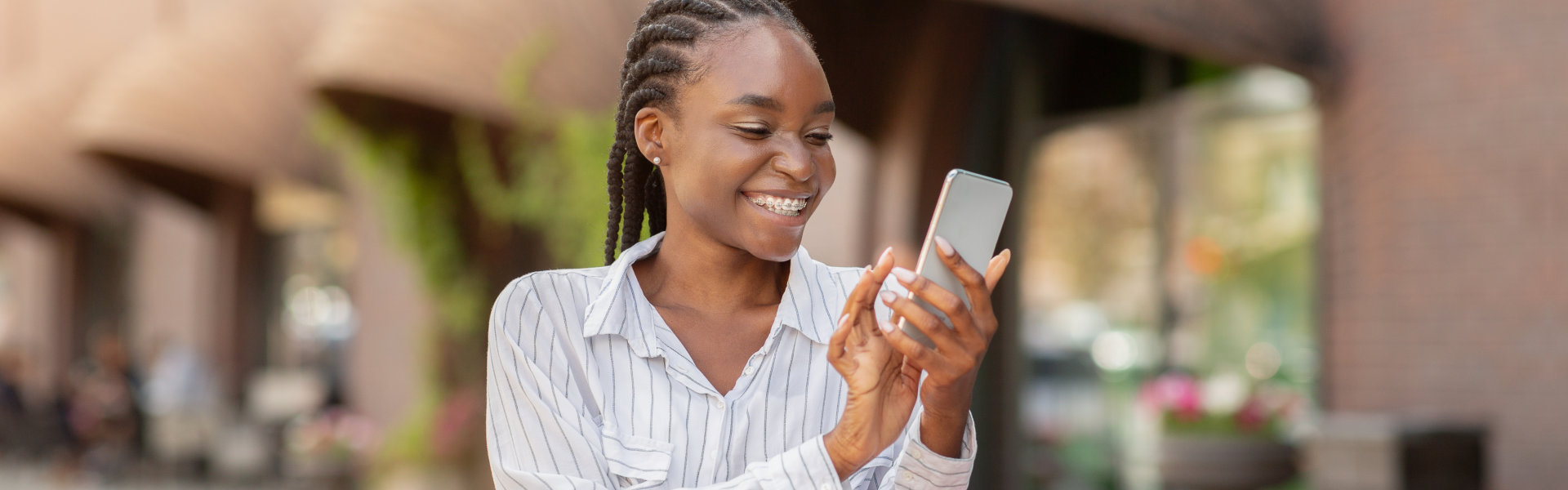 woman smiling while holding a phone